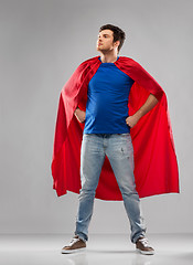 Image showing man in red superhero cape over grey background