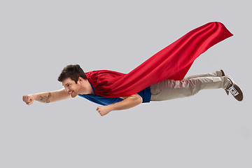 Image showing man in red superhero cape flying in air