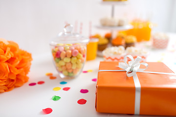 Image showing birthday present in orange wrap on table at party