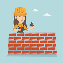 Image showing Young caucasian bricklayer building a brick wall.