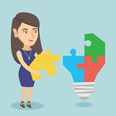 Image showing Businesswoman completing lightbulb made of puzzle.