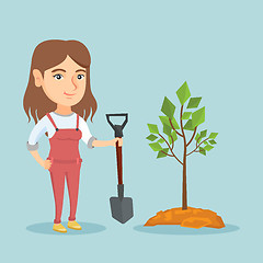 Image showing Young caucasian woman planting a tree.