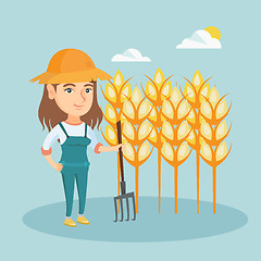 Image showing Young farmer standing in a field with pitchfork.