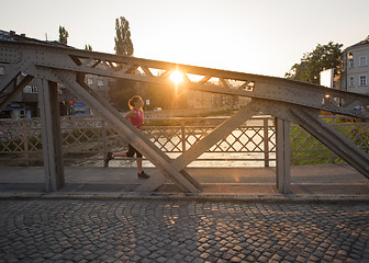 Image showing woman jogging across the bridge at sunny morning