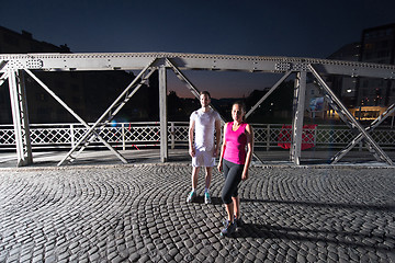 Image showing couple jogging across the bridge in the city