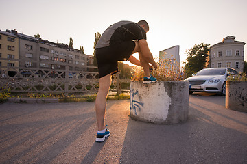 Image showing man tying running shoes laces