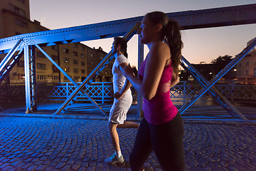 Image showing couple jogging across the bridge in the city