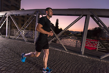 Image showing man jogging across the bridge in the city