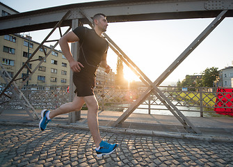 Image showing man jogging across the bridge at sunny morning