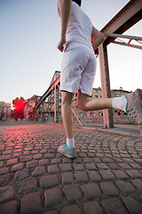 Image showing man jogging across the bridge at sunny morning