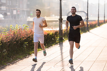 Image showing group of young people jogging in the city