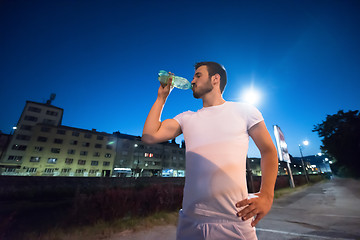 Image showing man drinking water after running session