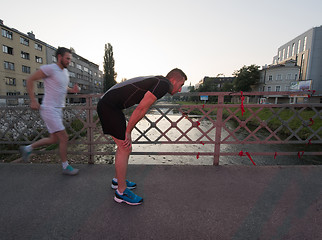 Image showing group of young people jogging across the bridge