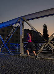 Image showing woman jogging across the bridge in the city