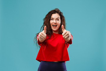 Image showing The happy business woman standing and smiling against blue background.