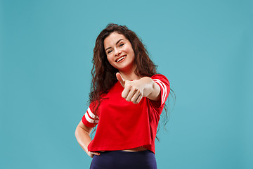 Image showing The happy business woman standing and smiling against blue background.