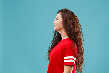 Image showing The happy business woman standing and smiling against blue background.