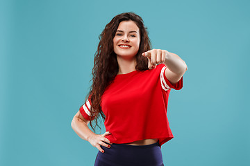 Image showing The happy business woman point you and want you, half length closeup portrait on blue background.