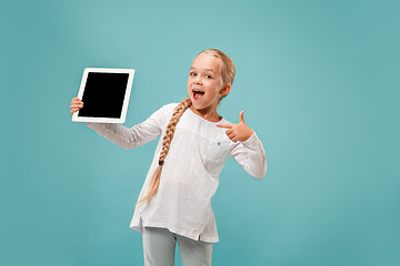 Image showing Little funny girl with tablet on blue background