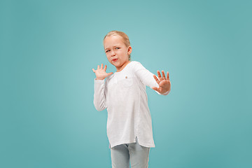 Image showing Doubtful pensive teen girl rejecting something against blue background