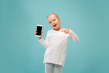 Image showing The happy teen girl standing and smiling against blue background.