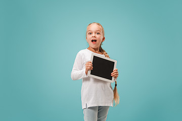 Image showing Little funny girl with tablet on blue background