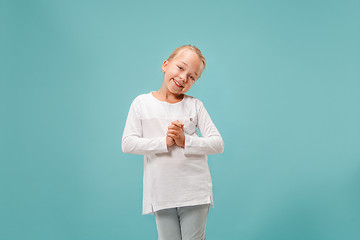 Image showing The happy teen girl standing and smiling against blue background.