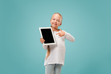 Image showing Little funny girl with tablet on blue background