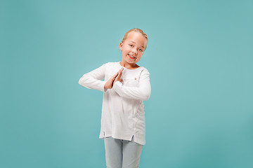 Image showing The happy teen girl standing and smiling against blue background.