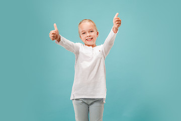 Image showing The happy teen girl standing and smiling against blue background.