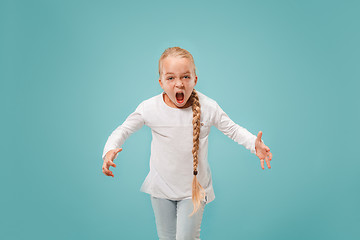 Image showing Portrait of angry teen girl on a blue studio background