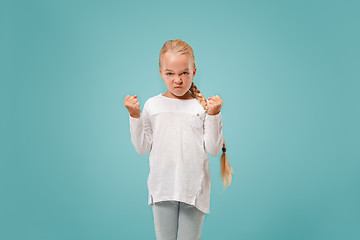 Image showing Portrait of angry teen girl on a blue studio background