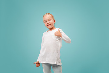 Image showing The happy teen girl standing and smiling against blue background.