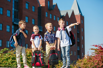 Image showing A group of children of school and preschool age are standing against sity