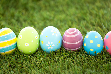 Image showing row of colored easter eggs on artificial grass