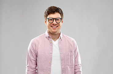 Image showing smiling young man in glasses over grey background