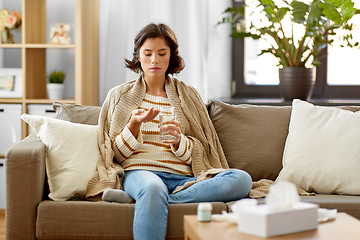 Image showing sick woman taking medicine with water at home