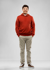 Image showing young man in red hoodie over grey background