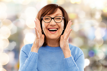 Image showing senior woman in glasses calling over grey