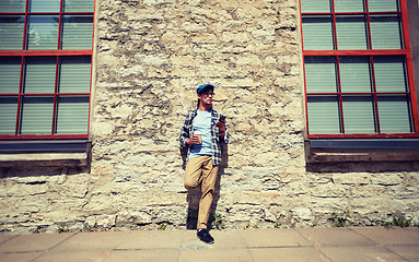 Image showing man with smartphone drinking coffee on city street