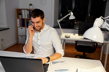 Image showing businessman calling on smartphone at night office