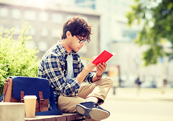 Image showing man with notebook or diary writing on city street