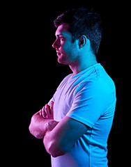 Image showing man with crossed arms over neon lights in darkness