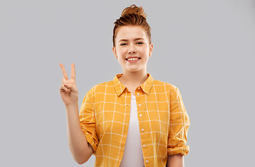 Image showing smiling red haired teenage girl showing peace