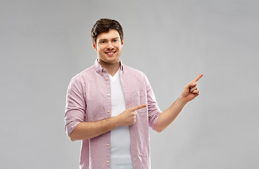 Image showing smiling young man showing something