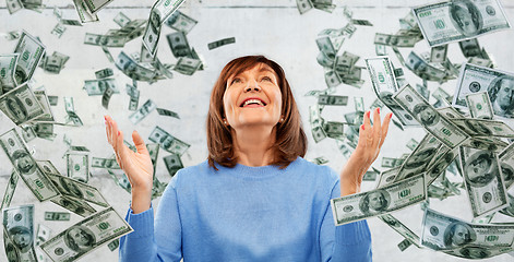 Image showing grateful senior woman and money falling from above