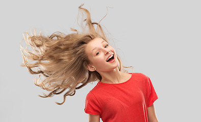 Image showing smiling teenage girl in red with long wavy hair