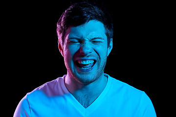 Image showing man laughing over neon lights in dark room