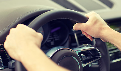Image showing close up of male hands driving car
