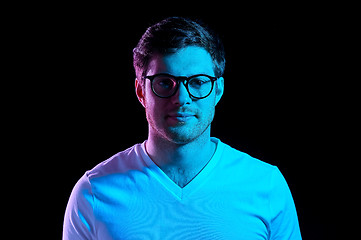 Image showing man in glasses over neon lights in dark room